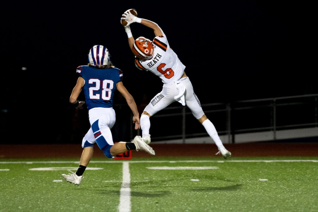 Reece Huber of the Heath Bulldogs leaping for the catch to complete a pass in their game against the Lakewood Lancers, in Hebron, Ohio, on Friday, Sept. 24, 2021. The Bulldogs went to win the game with a score of 68-14. [Alex Eicher | WOUB]