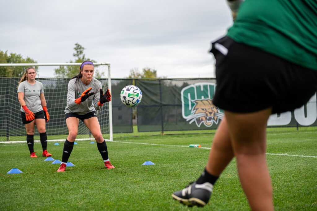Ohio University keepers Sam Wexell (front) and Reese Dorsey (back) warming up with their coach Gabby Isola before their game at Chessa Field vs the Western Michigan Broncos on Thursday, Oct. 7, 2021. The Bobcats went to win the game 3-1. [Alex Eicher | The Post]