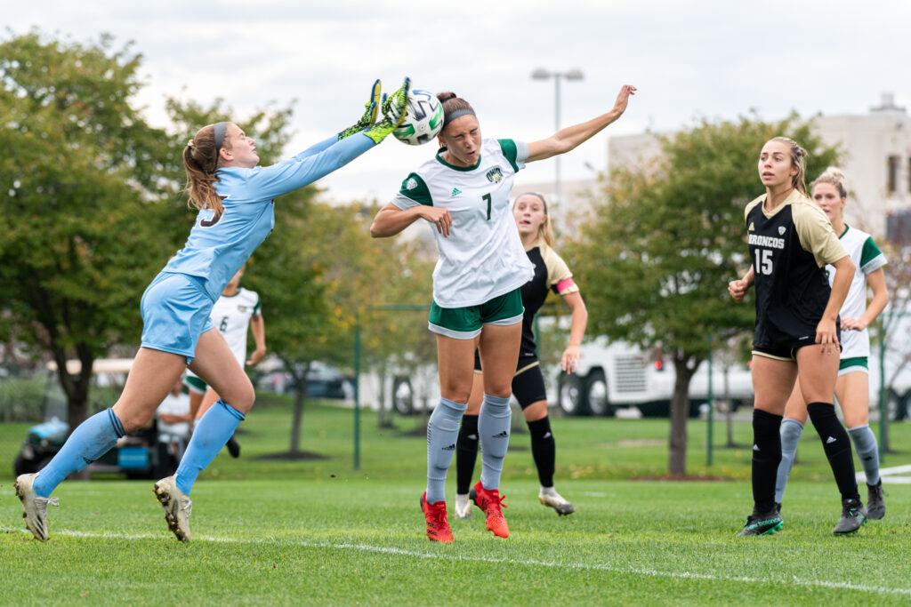 Western Michigan keeper Maggie Rogers blocks a headder from Madison Clayton (7) of the Ohio University Bobcats during their game at Chessa Field vs Ohio University on Thursday, Oct. 7, 2021. The Bobcats went to win the game 3-1. [Alex Eicher | The Post]